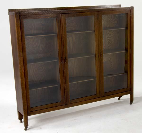 Appraisal: ARTS CRAFTS Three door bookcase of quartersawn oak with adjustable