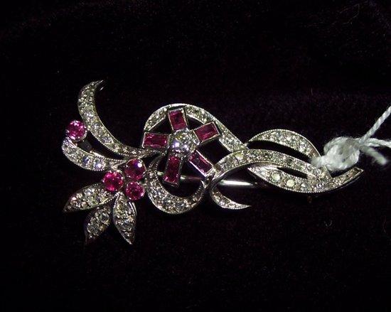 Appraisal: A diamond and ruby set brooch of scrolling foliate form