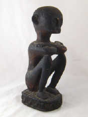 Appraisal: A carved wooden figure of a seated African ht cm