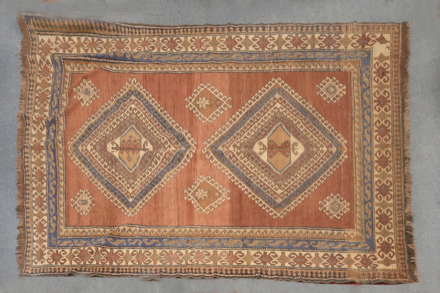 Appraisal: A TURKISH RED GROUND RUG with the design of hooked