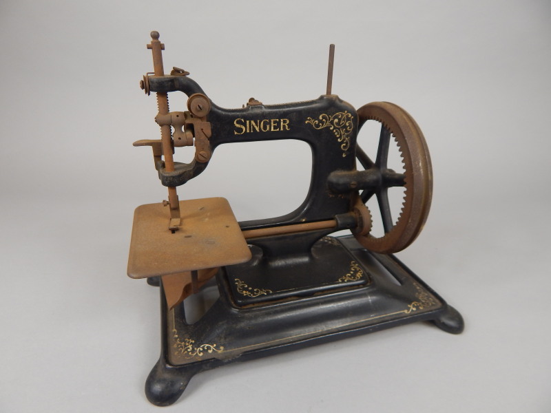 Appraisal: A Singer cast iron sewing machine decorated with scrolls on