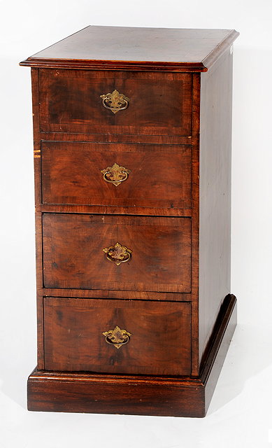 Appraisal: A NARROW WALNUT CHEST of four drawers standing on a