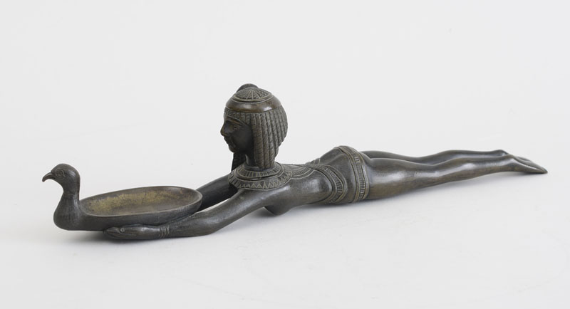 Appraisal: EGYPTIAN STYLE BRONZE FIGURE OF A RECLINING SLAVE GIRL HOLDING