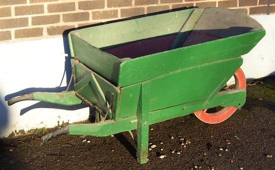 Appraisal: A green painted wheelbarrow the red spoked wheel with an