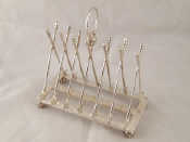 Appraisal: A silver plated six slice toast rack formed as golf