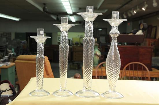 Appraisal: FOUR BLOWN GLASS CANDLESTICKS Clear glass sticks with twisted stems