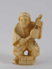 Appraisal: A Japanese ivory netsuke of a musician with drum ht