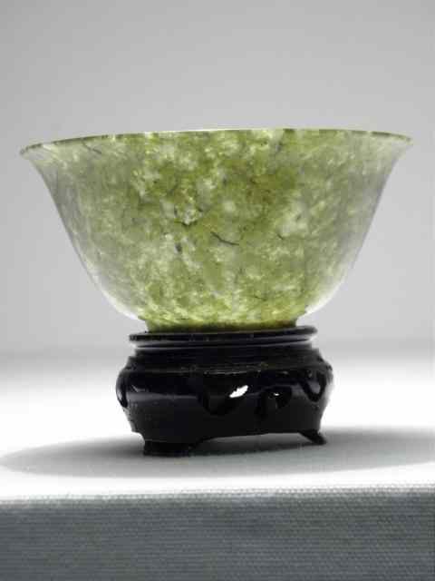 Appraisal: Thinly carved Nephrite green jade bowl Includes small wooden stand