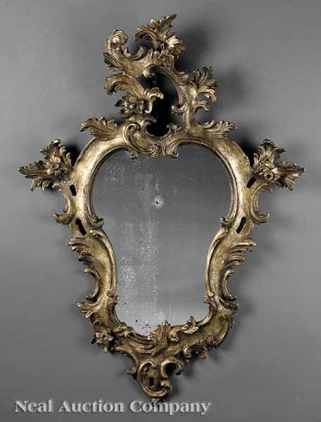 Appraisal: An Italian Rococo-Style Silvered Mirror foliate and floral pierced crest