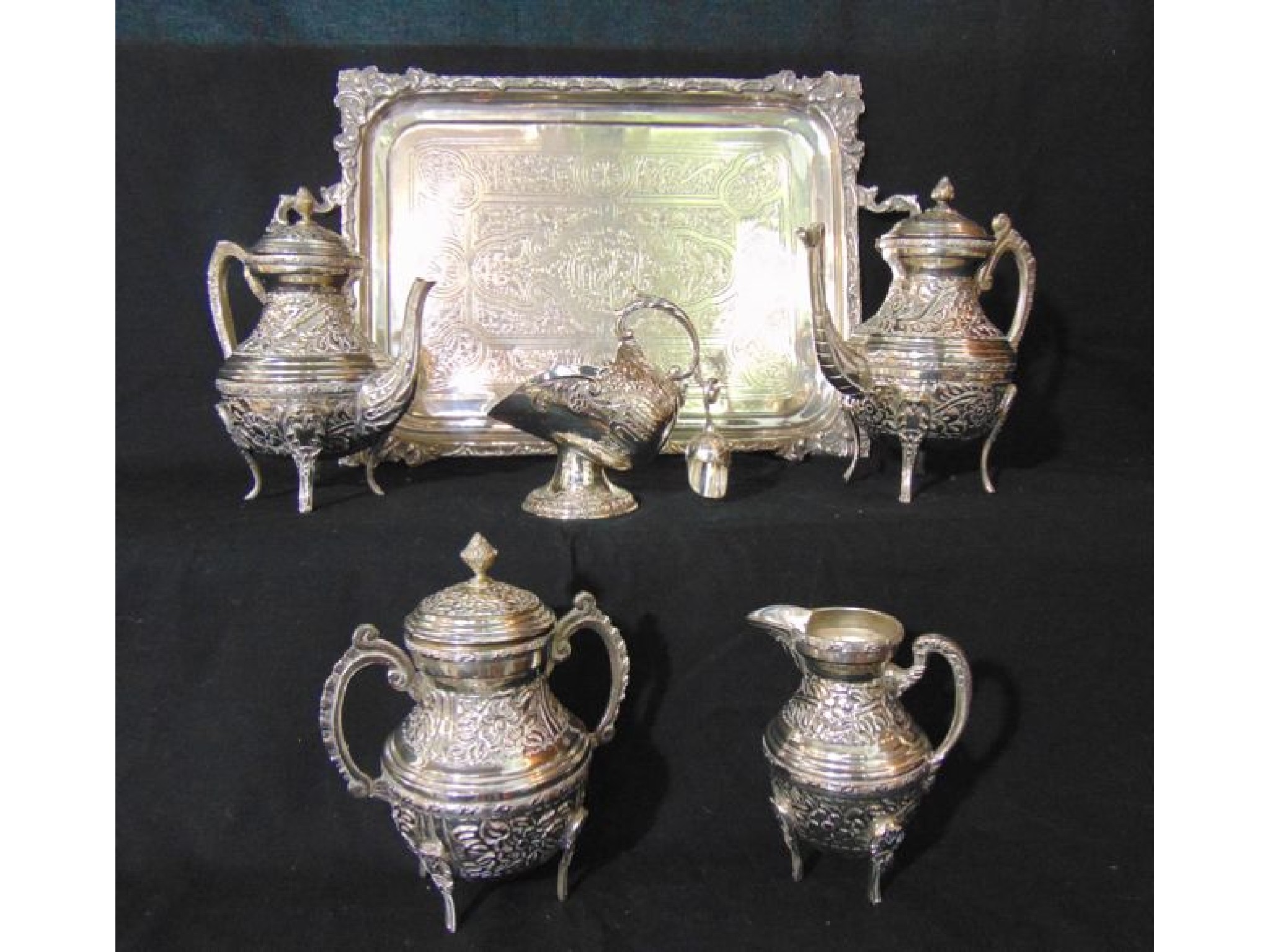 Appraisal: A four piece eastern white metal tea set comprising teapot