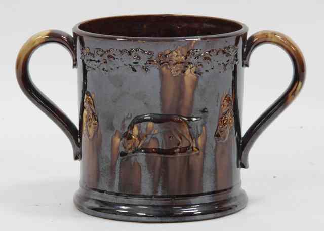 Appraisal: A th Century treacle glaze two-handled loving cup applied with