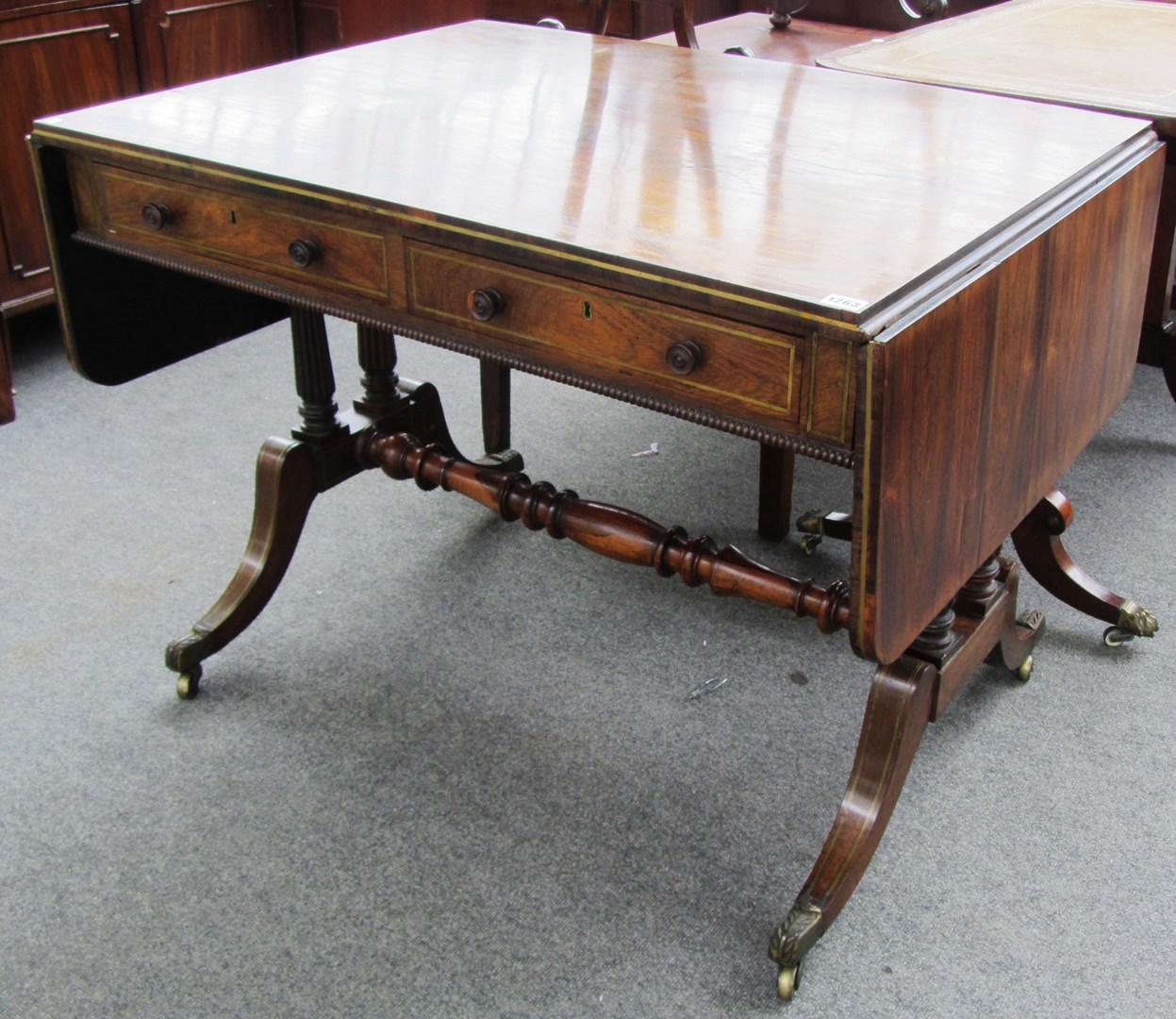 Appraisal: An early th century brass inlaid rosewood sofa table on