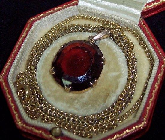 Appraisal: A garnet pendant in unmarked gold setting the large single