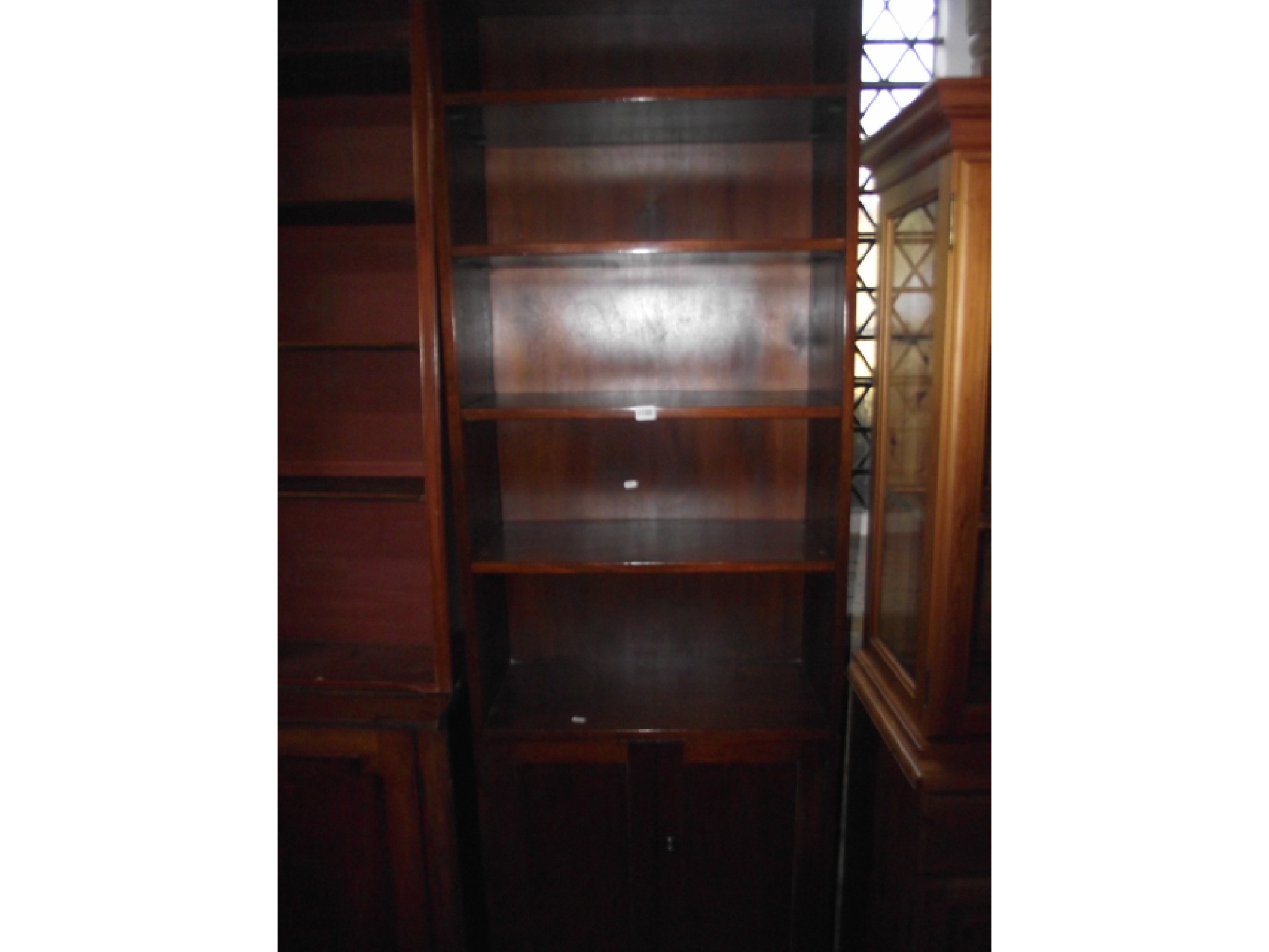 Appraisal: An upright teakwood cabinet the lower section enclosed by a