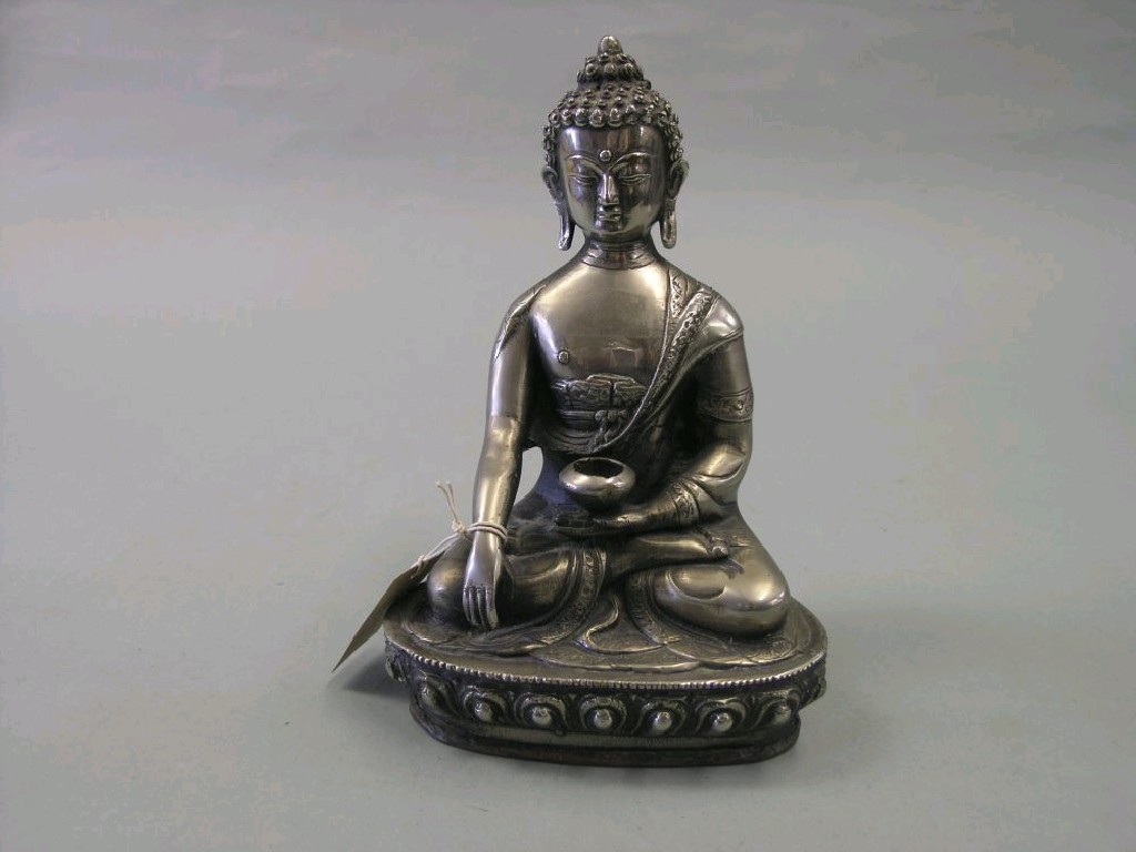 Appraisal: An Indian polished metal Buddha seated pose on gadrooned base