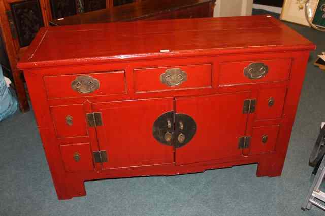 Appraisal: A CHINESE RED LACQUER SIDE CABINET having traditional arrangement of