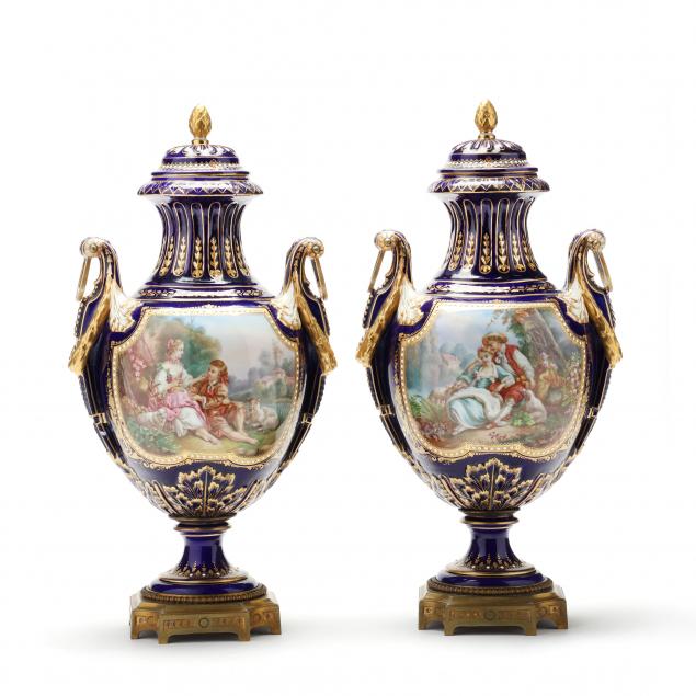 Appraisal: PAIR OF FRENCH WATTEAU SCENE COVERED MANTEL URNS th century