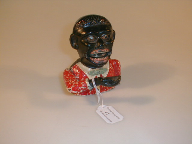 Appraisal: A painted cast iron Negro money box with hand flipping