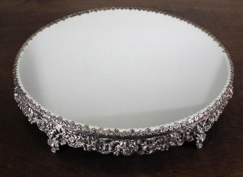 Appraisal: ROUND PLATEAU MIRROR with silver plated repousse footed frame Diameter