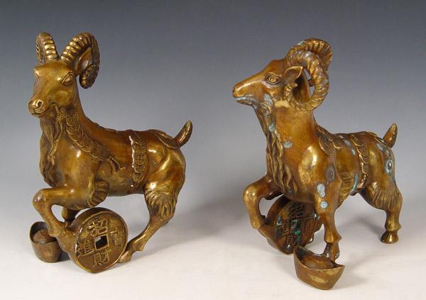 Appraisal: TWO DECORATIVE CHINESE BRONZE STATUES OF GOATS Decorated with coins