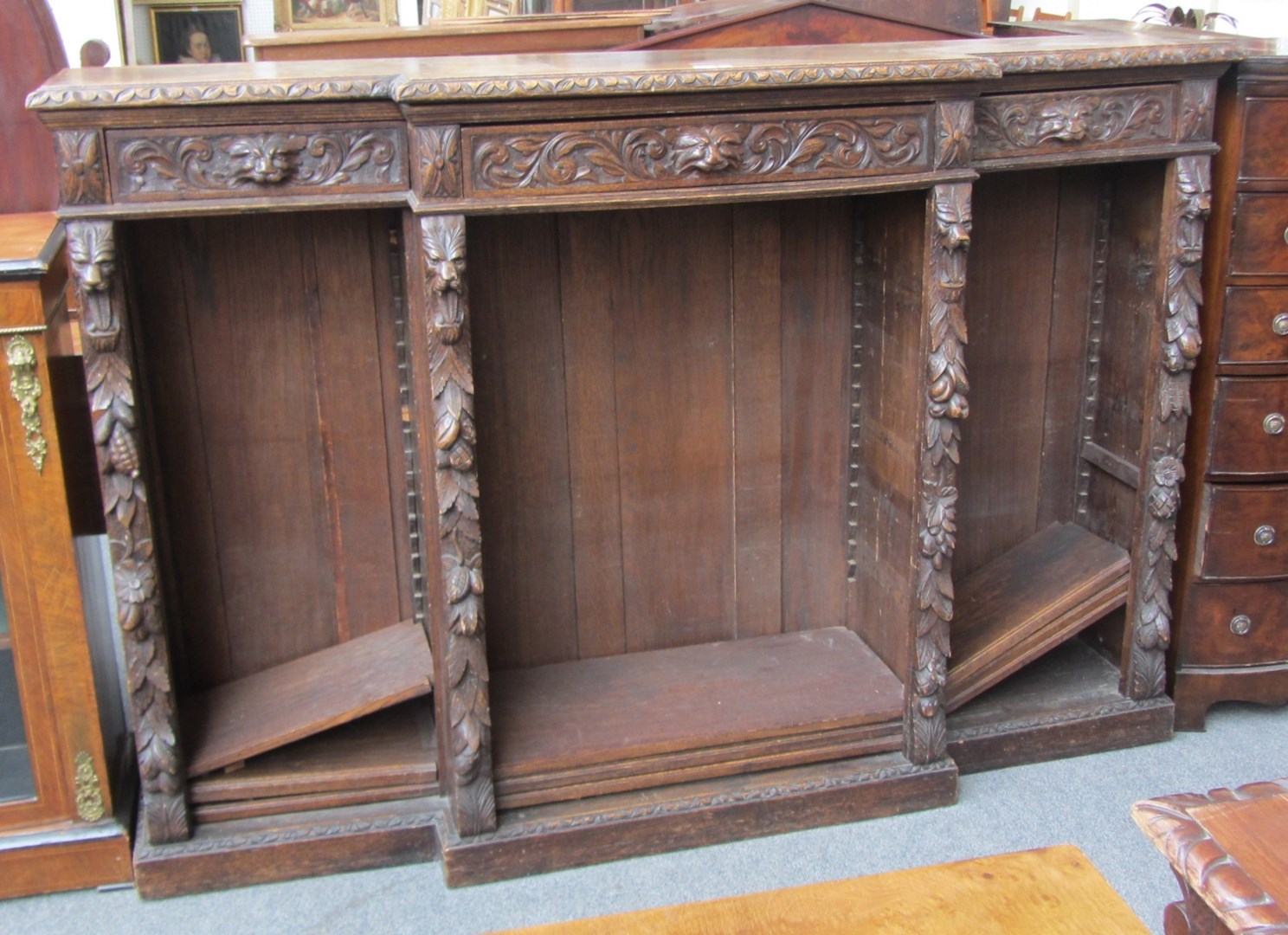 Appraisal: A Victorian carved oak breakfront bookcase decorated with foliage and