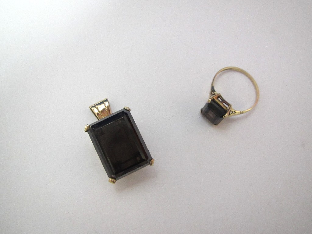 Appraisal: A large step cut smoky quartz pendant and matching dress