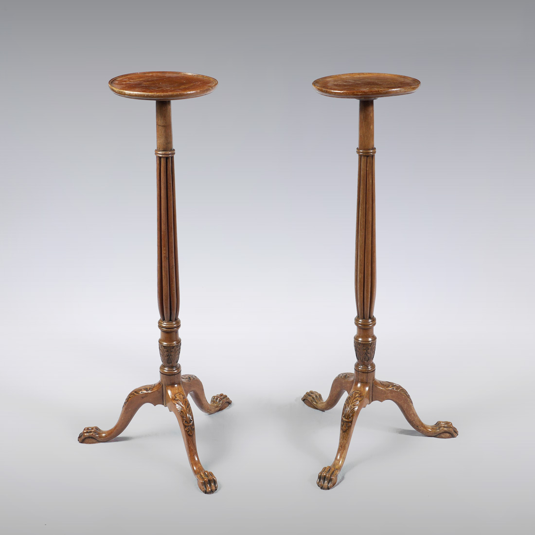 Appraisal: PAIR OF EDWARDIAN CARVED WOOD PLANT STANDS Round tops fluted