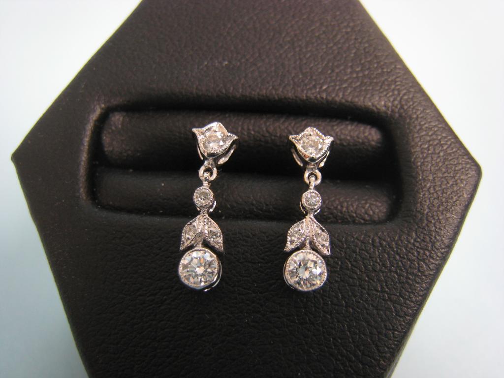 Appraisal: A pair of Diamond Earrings each with leafage plaque collet-set