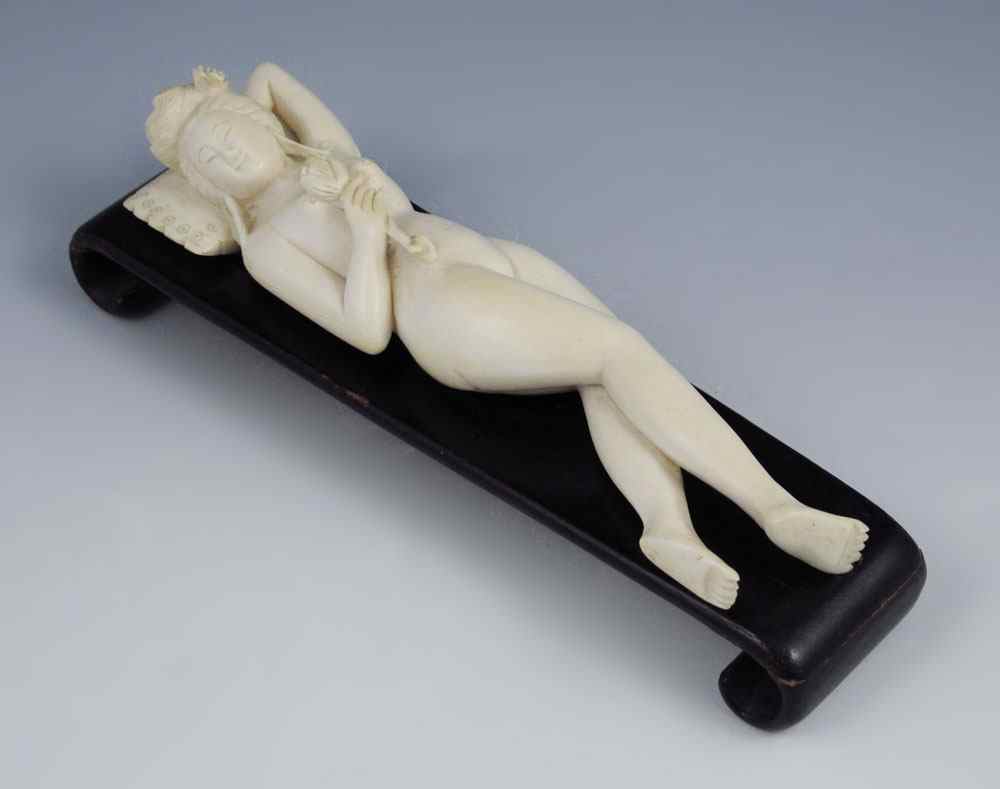 Appraisal: CARVED IVORY DOCTOR'S LADY Reclining nude woman holding flower Unsigned