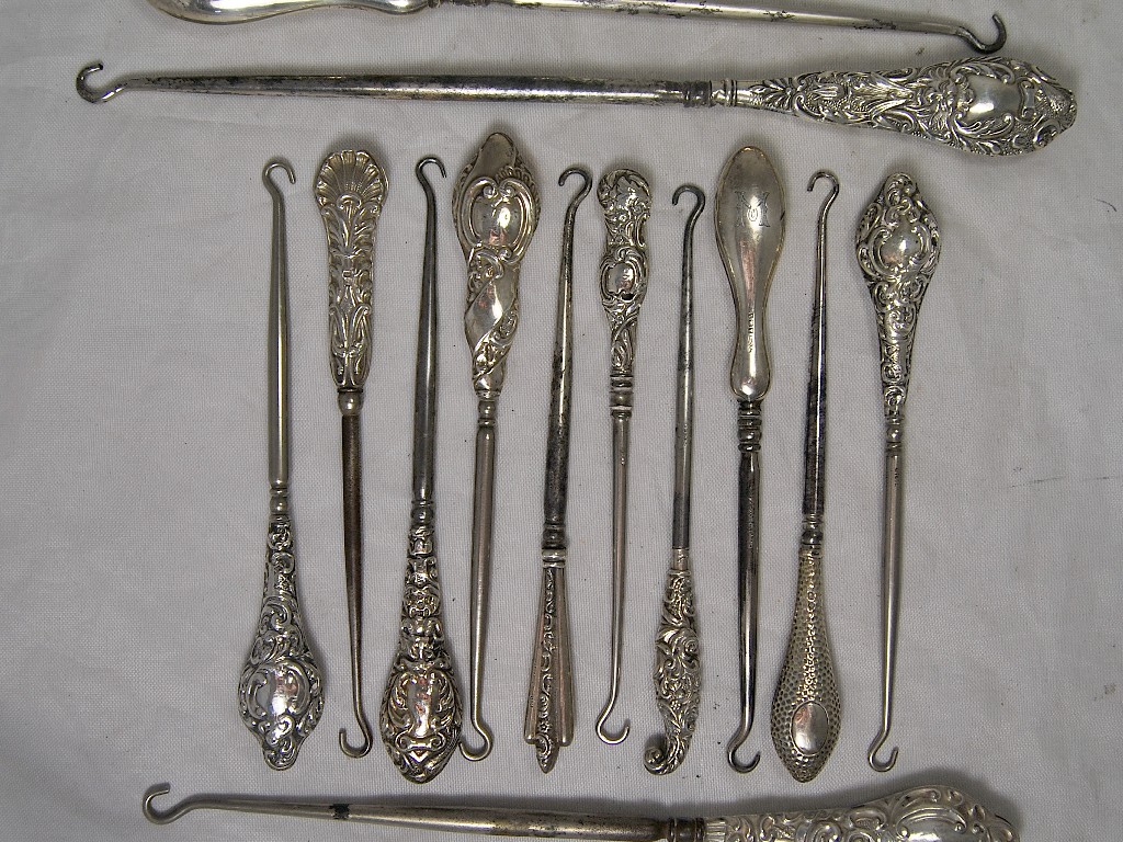 Appraisal: Thirteen silver handle steel button hooks mostly having decorative handles