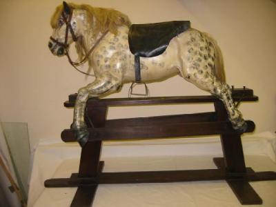 Appraisal: A painted metal rocking horse with dappled finish leather ears