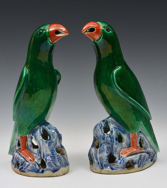 Appraisal: A PAIR OF CHINESE BISCUIT PORCELAIN DARK GREEN GLAZED PARROTS