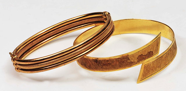 Appraisal: A YELLOW METAL BANGLE with engine turned type decoration and