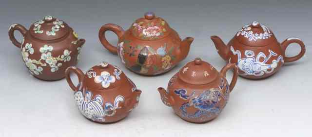 Appraisal: A COLLECTION OF FIVE SMALL YIXING TEAPOTS each with polychrome