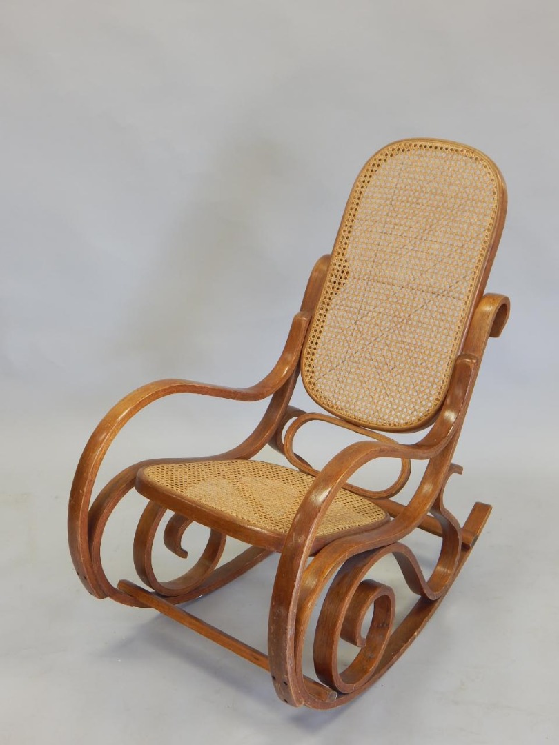 Appraisal: A bentwood rocking chair with a caned back and seat