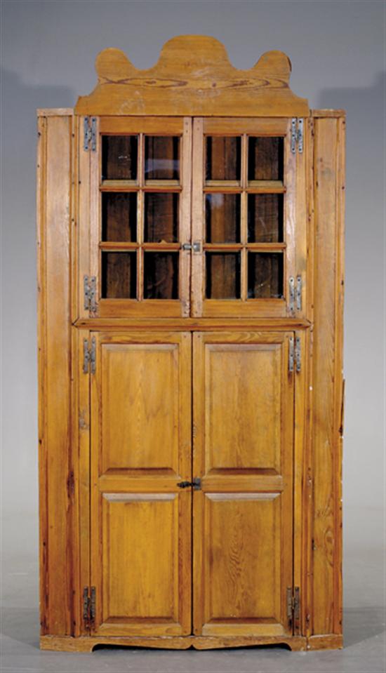 Appraisal: American heart pine corner cupboard th century exaggerated scalloped cornice