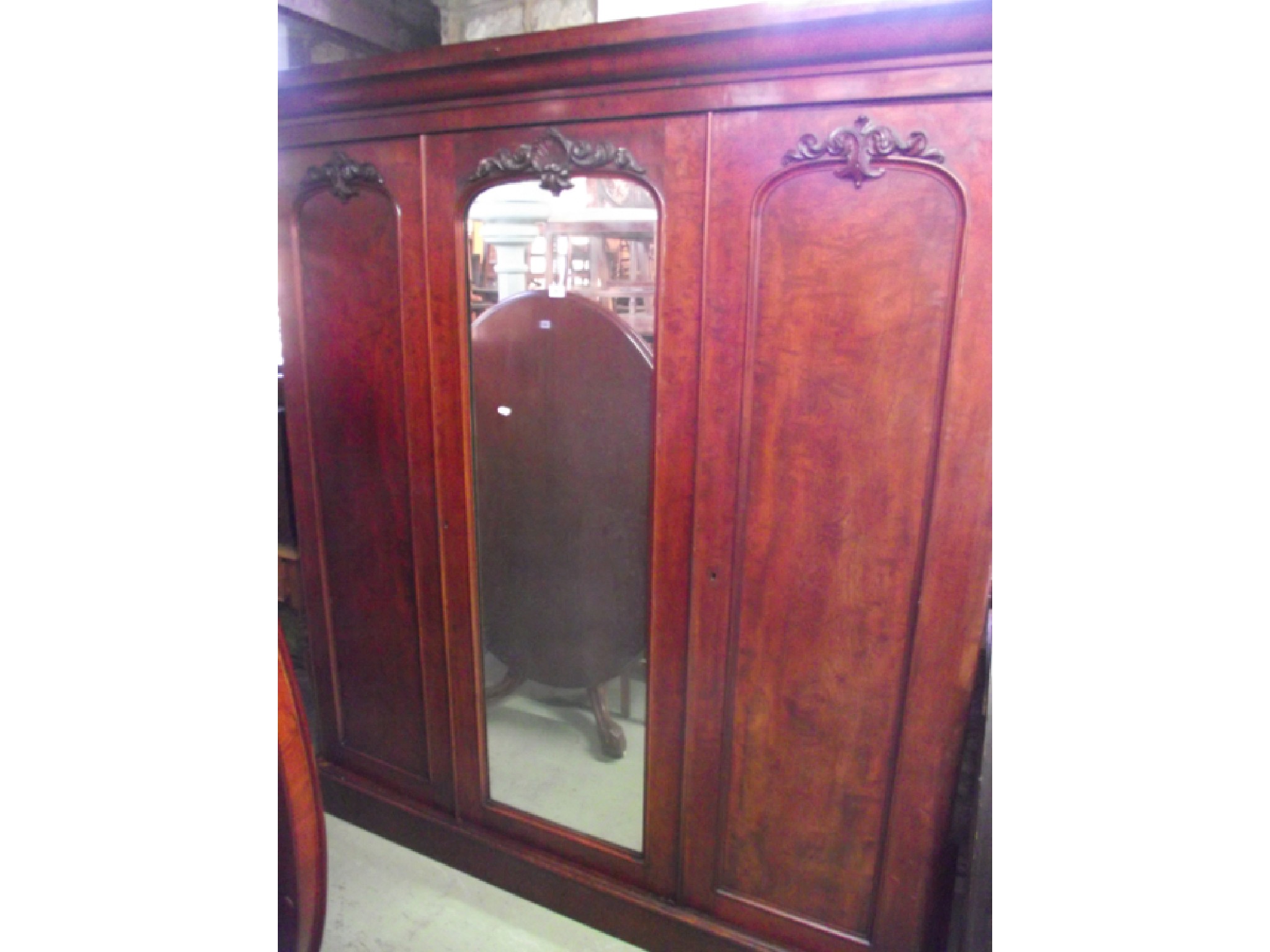 Appraisal: A substantial Victorian mahogany triple wardrobe the central mirror panelled