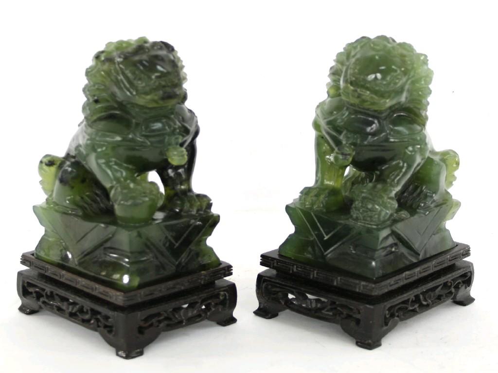 Appraisal: Pair of green jade carved Dogs of Fo crouching on