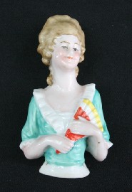 Appraisal: An Art Deco half doll with powdered wig holding a