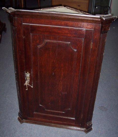 Appraisal: A George III oak hanging corner cupboard with moulded cornice