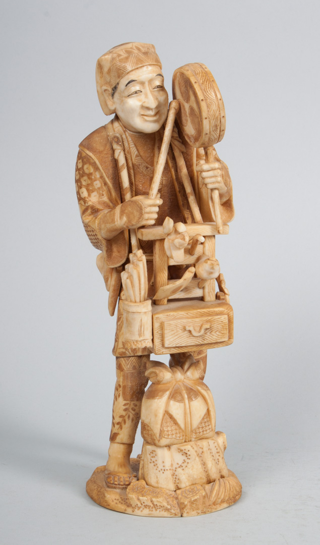 Appraisal: Japanese carved ivory street peddler modeled as man carrying his