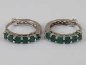 Appraisal: A pair of white metal tests silver emerald hoop earrings