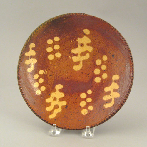 Appraisal: Medinger redware plate with yellow slip decoration dia