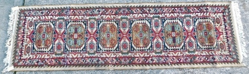 Appraisal: A machine woven runner with a design of medallions on