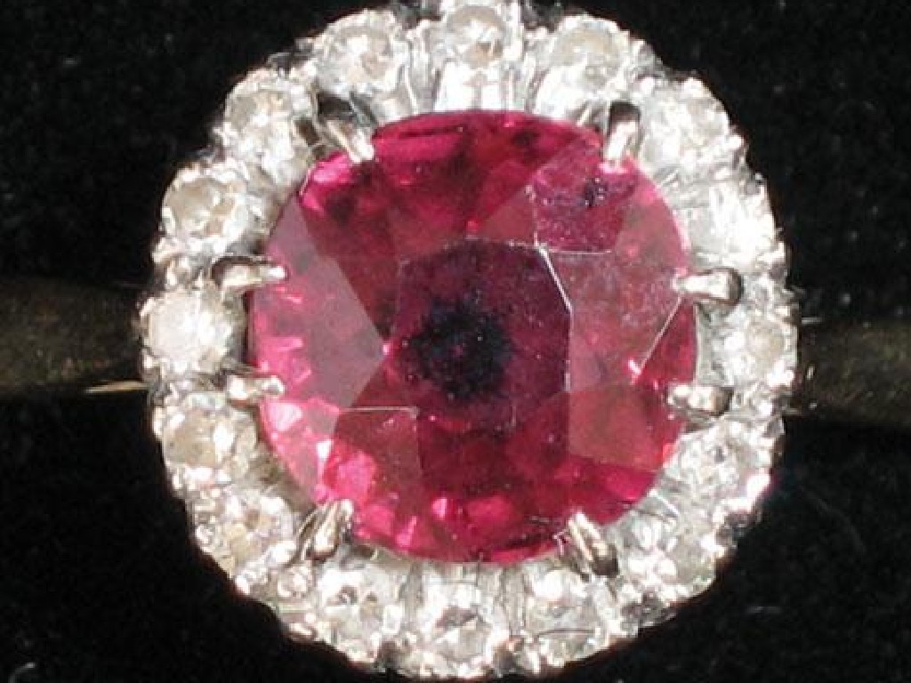 Appraisal: A RED TOURMALINE AND DIAMOND RING the central cushion-cut tourmaline