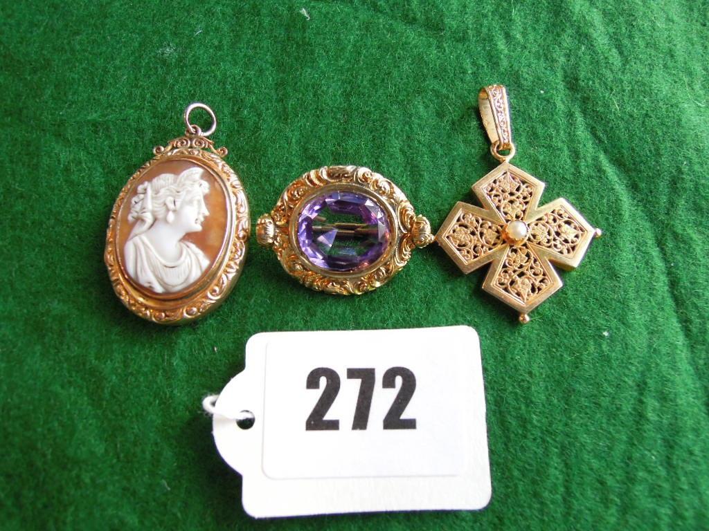 Appraisal: An amethyst brooch within an oval surmount with engraved scrolling