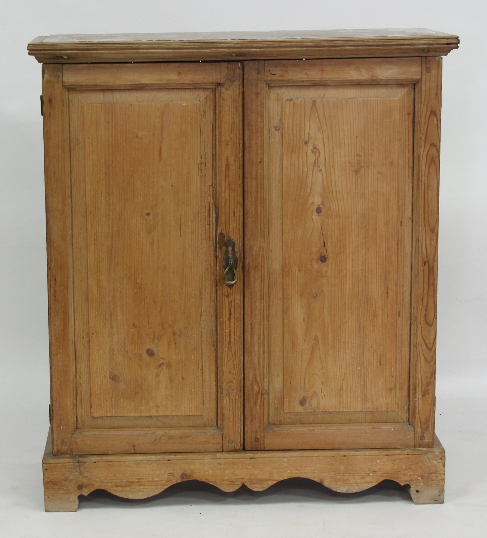 Appraisal: A pine cupboard enclosed by two fielded panel doors on