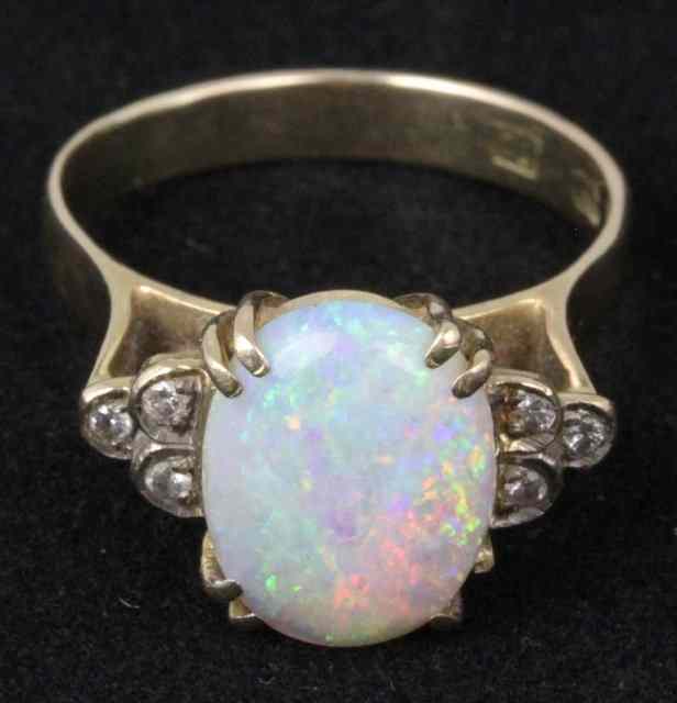 Appraisal: An opal dress ring the oval stone with three small