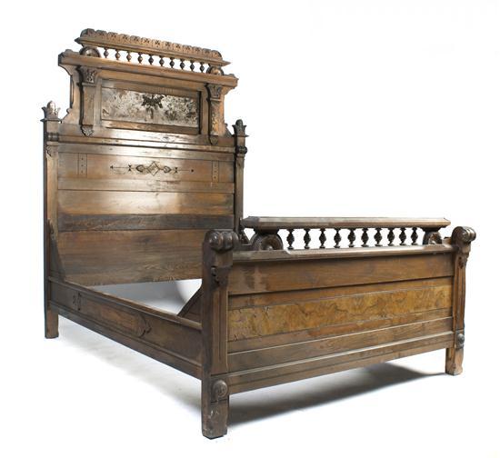 Appraisal: A Victorian Walnut Bed with spindle and carved crest having