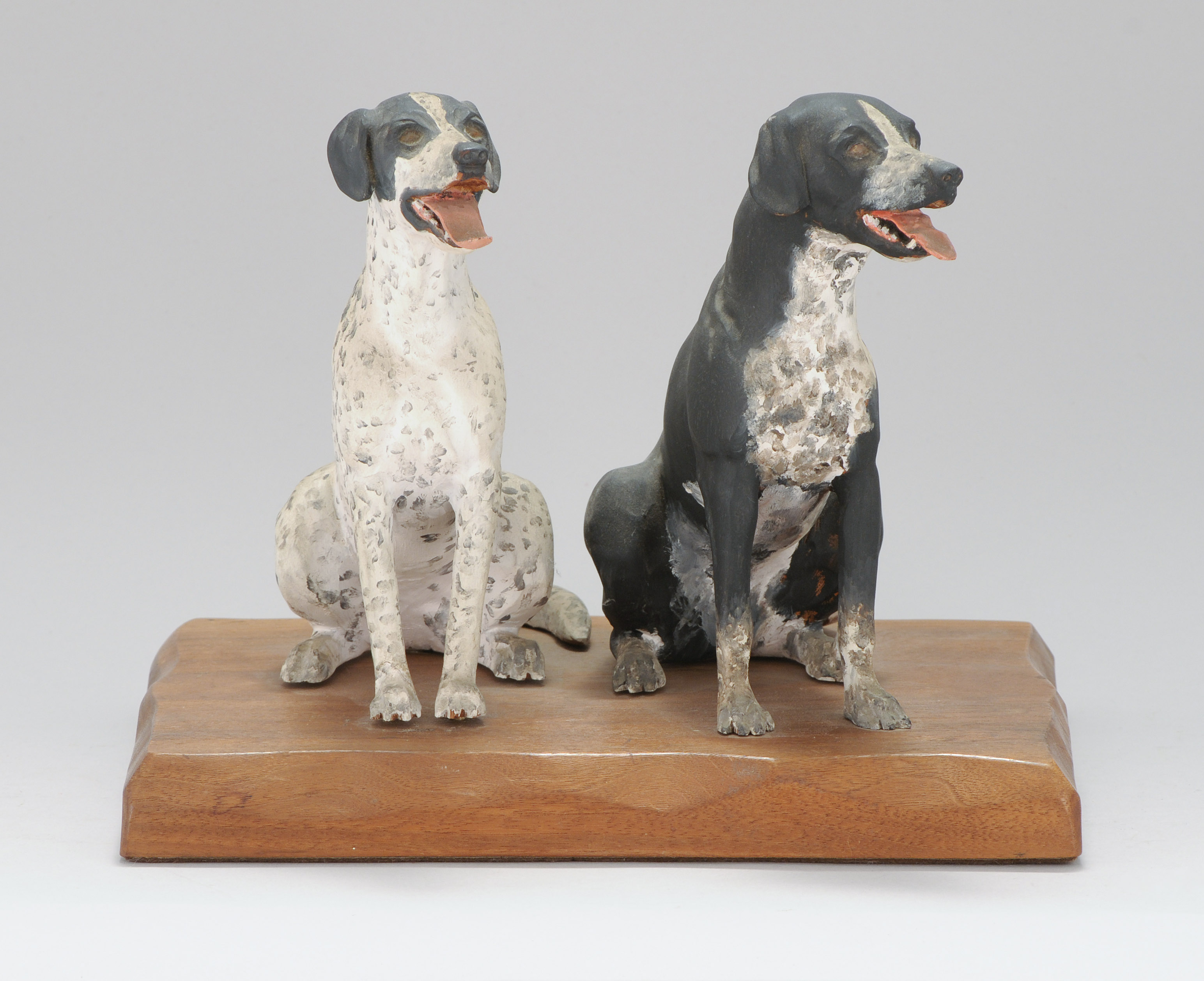 Appraisal: PAIR OF CARVED WOODEN HUNTING DOGS Seated on a chip-carved